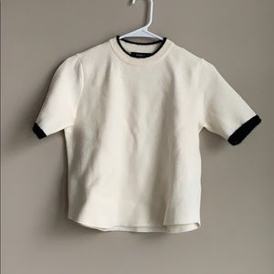 White top with black arm and neckline details